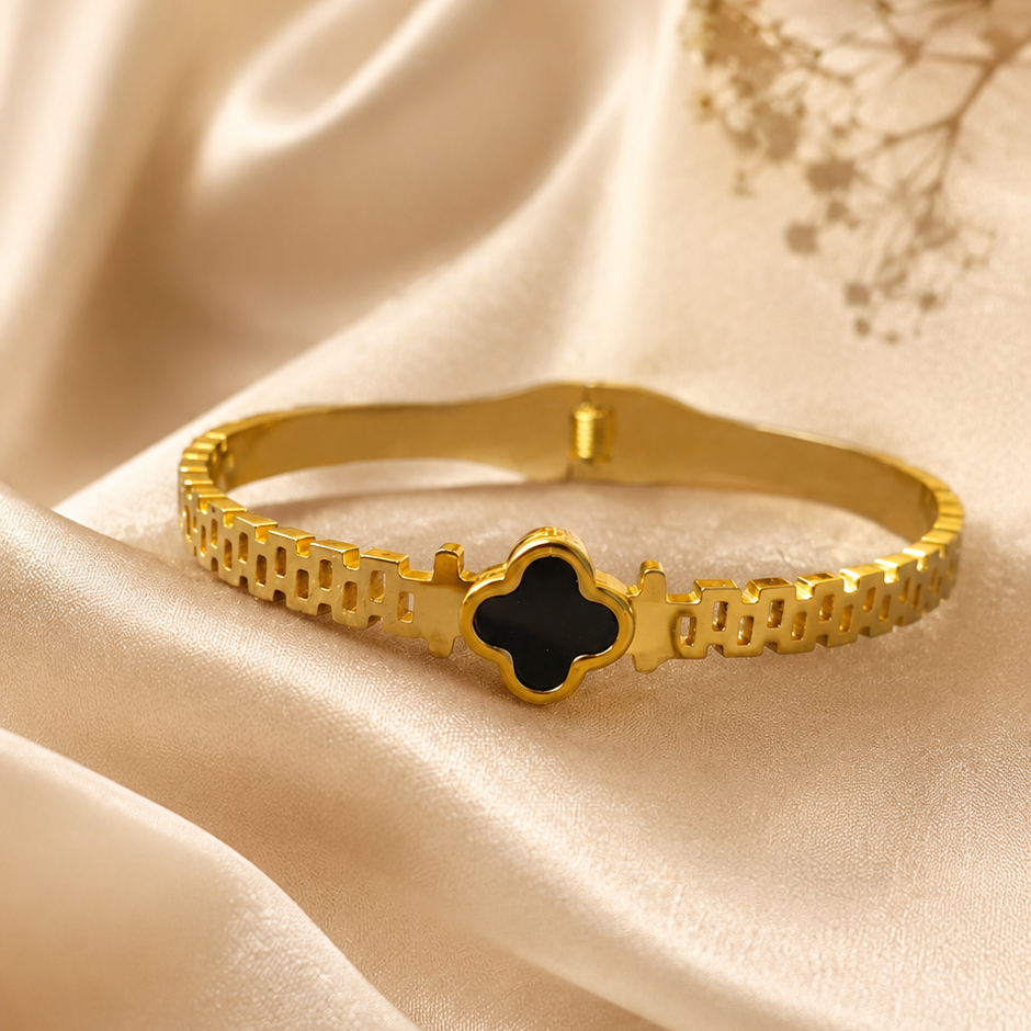 Gold bracelet with a black clover-shaped center 