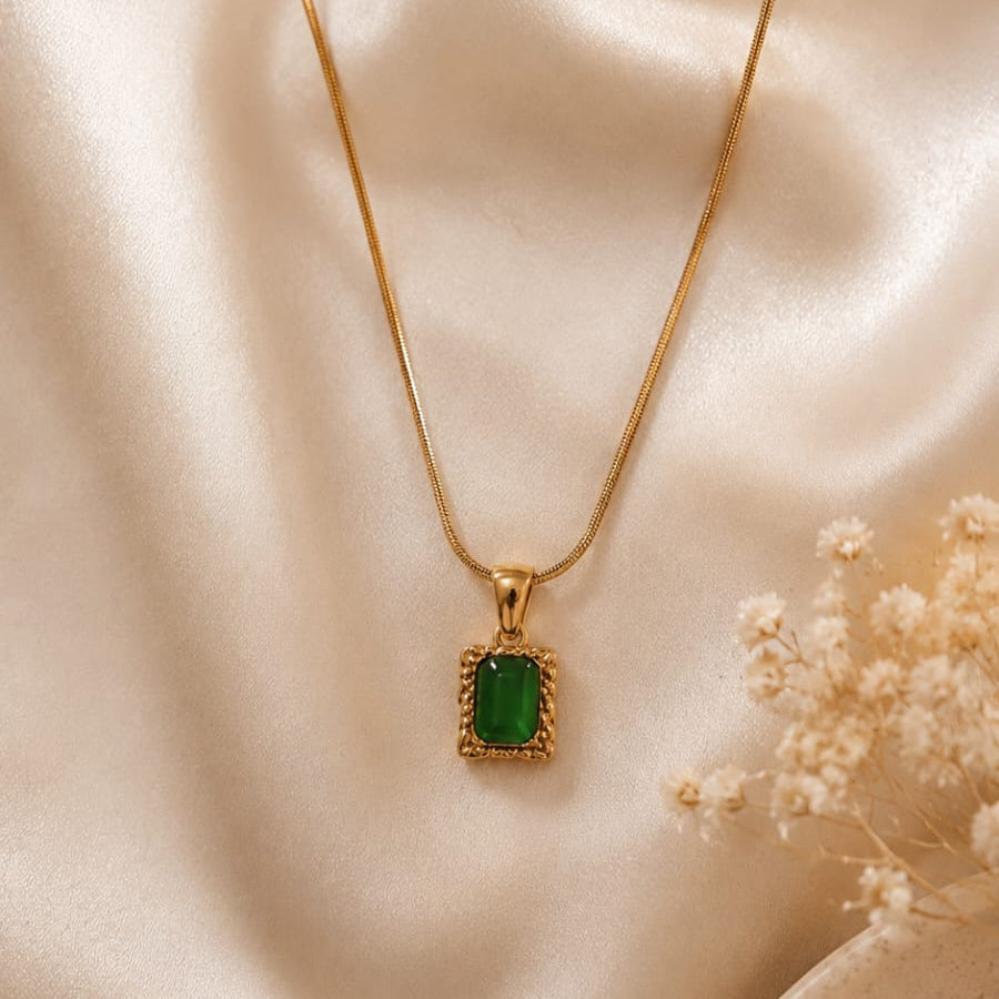 Gold necklace with a green pendant 